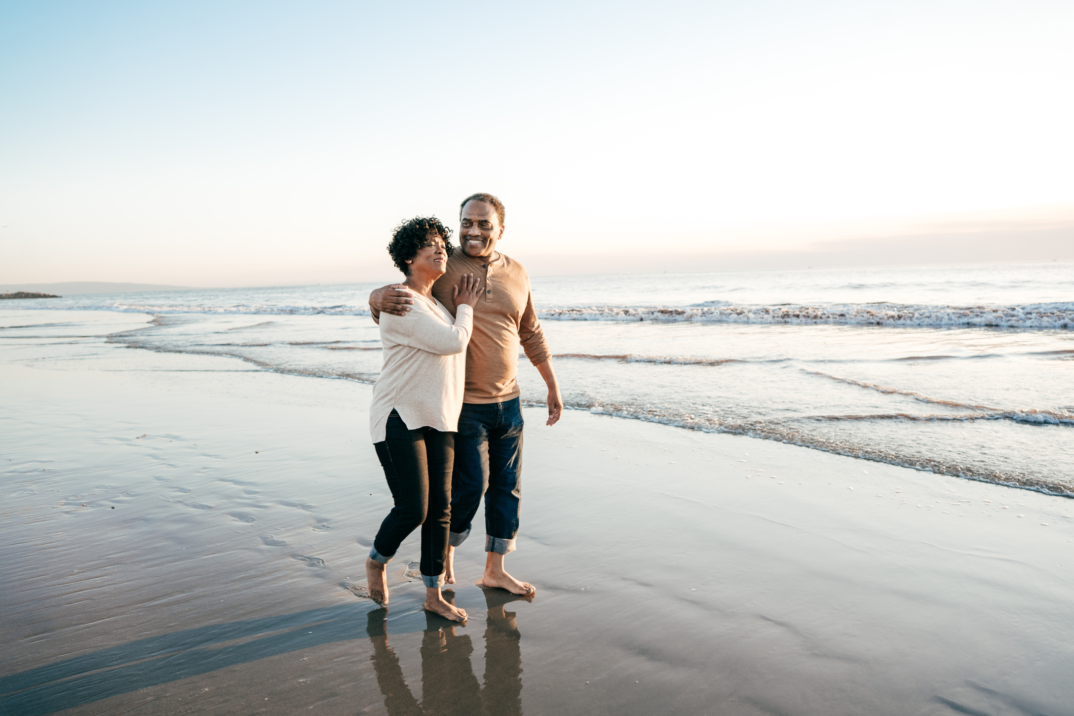 Senior men walking with senior women on the beach