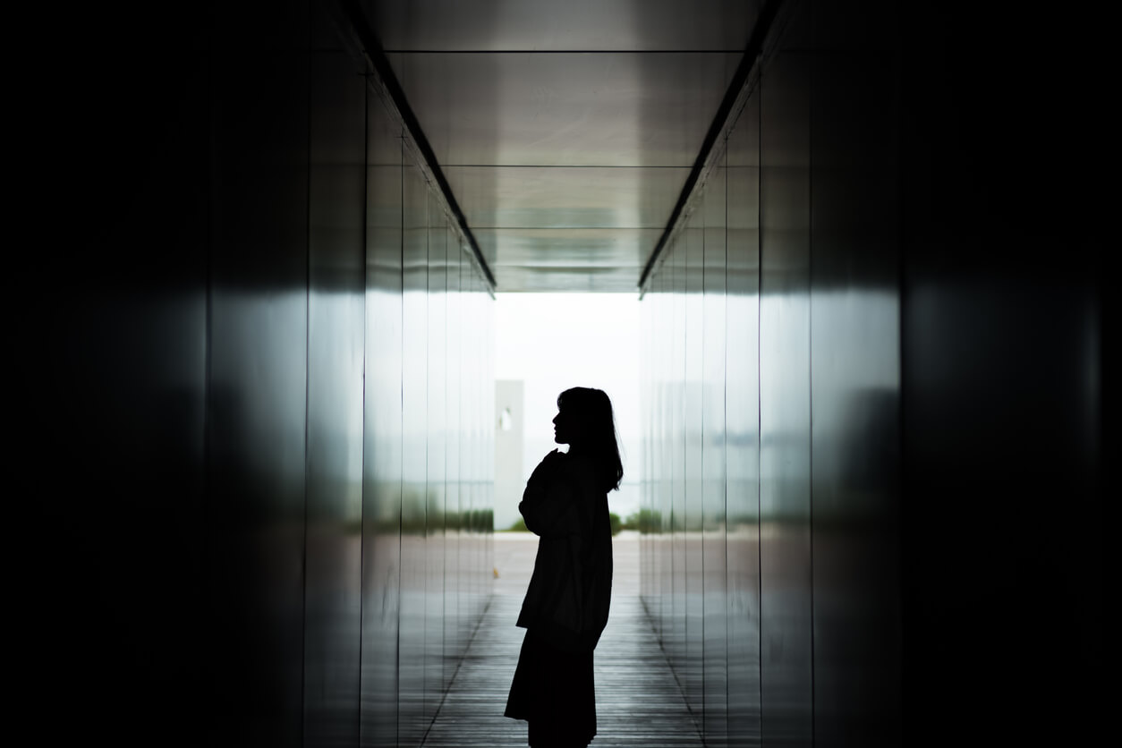 A girl standing in a dark corridor