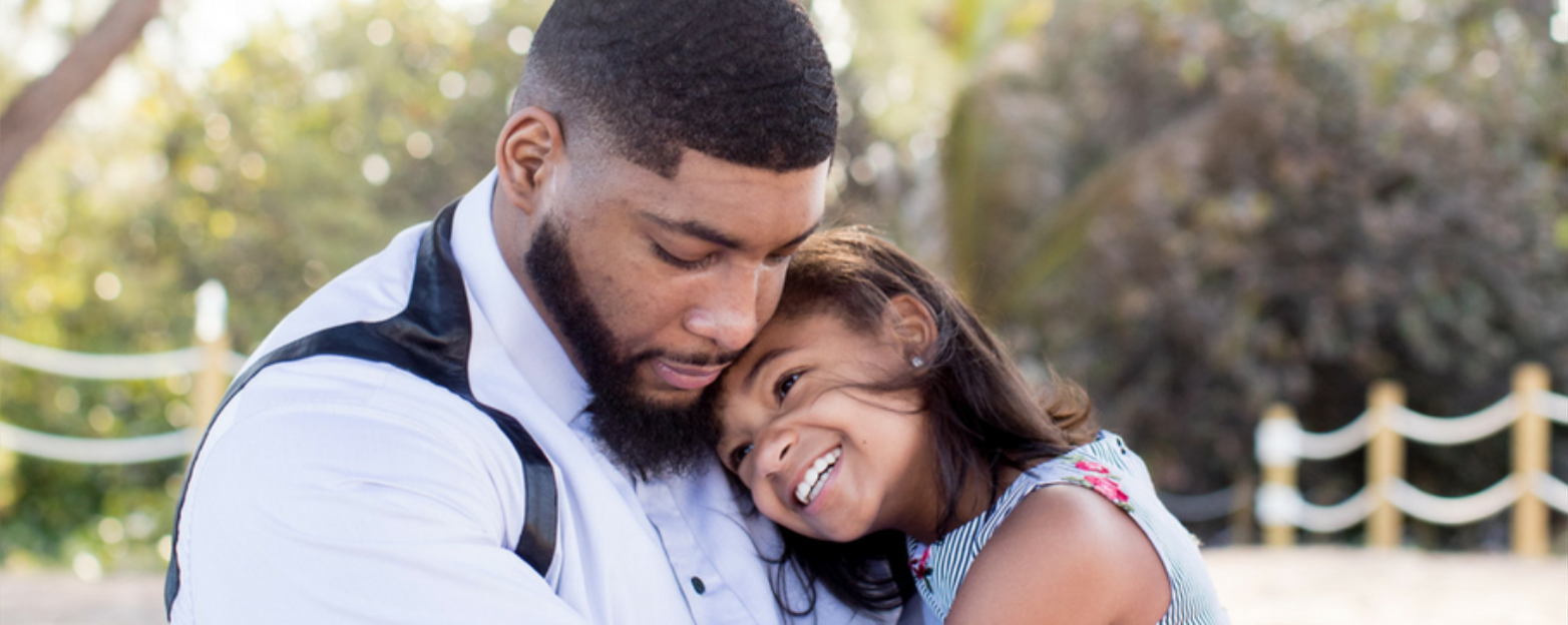 Father hugging his daughter outdoors