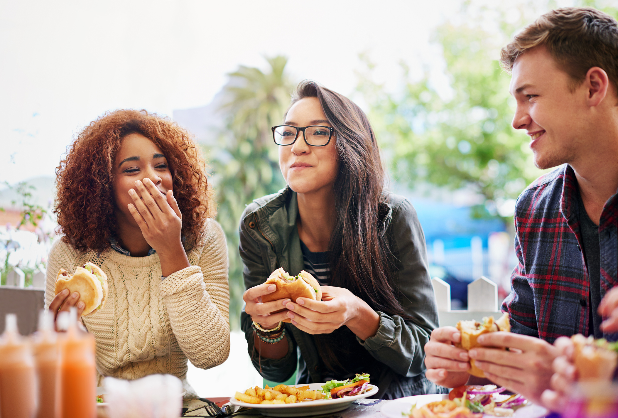 Friends eating burgers outdoors