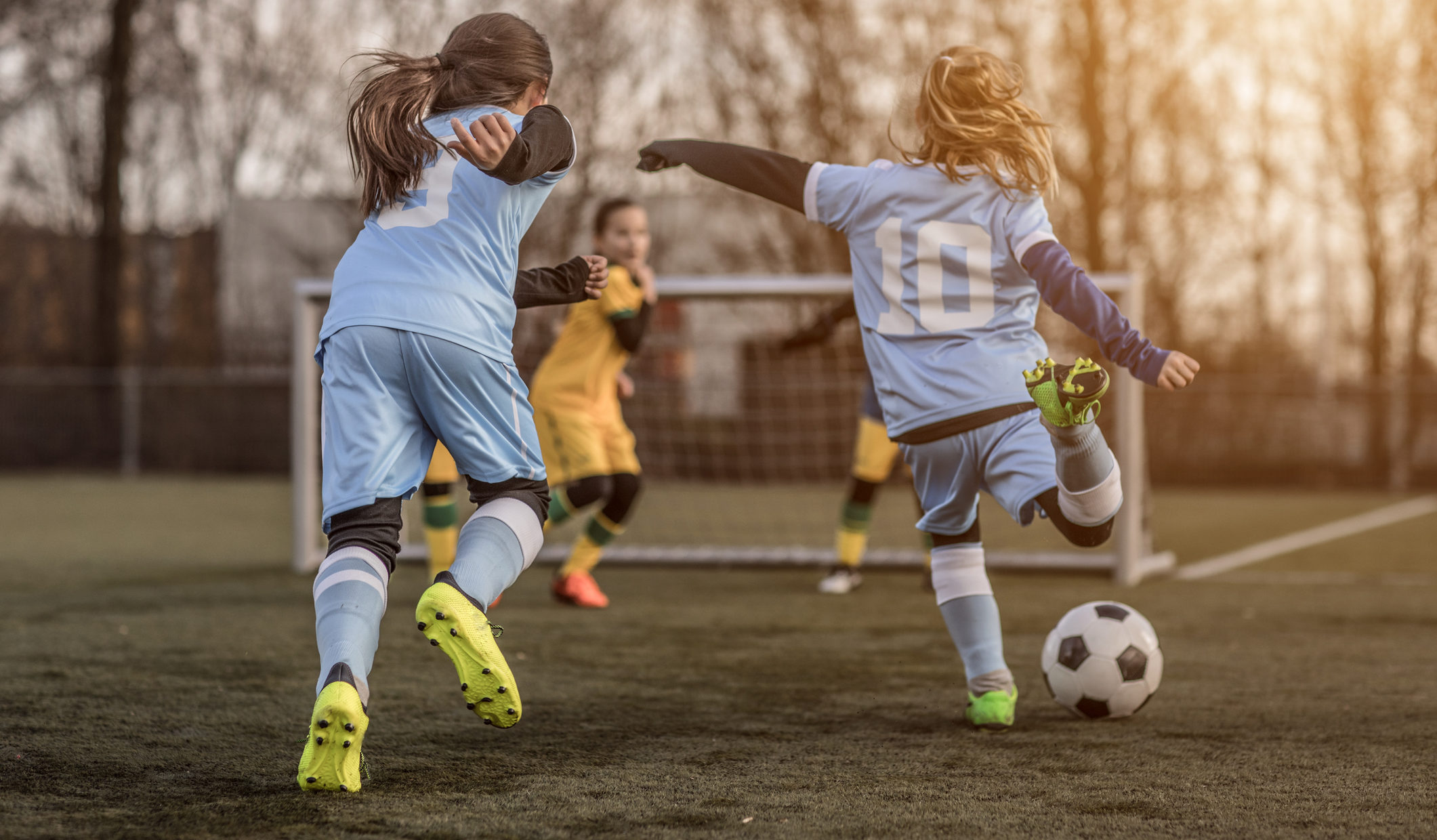 Two Female Girl Soccer Teams playing a football training match in the Spring outdoors