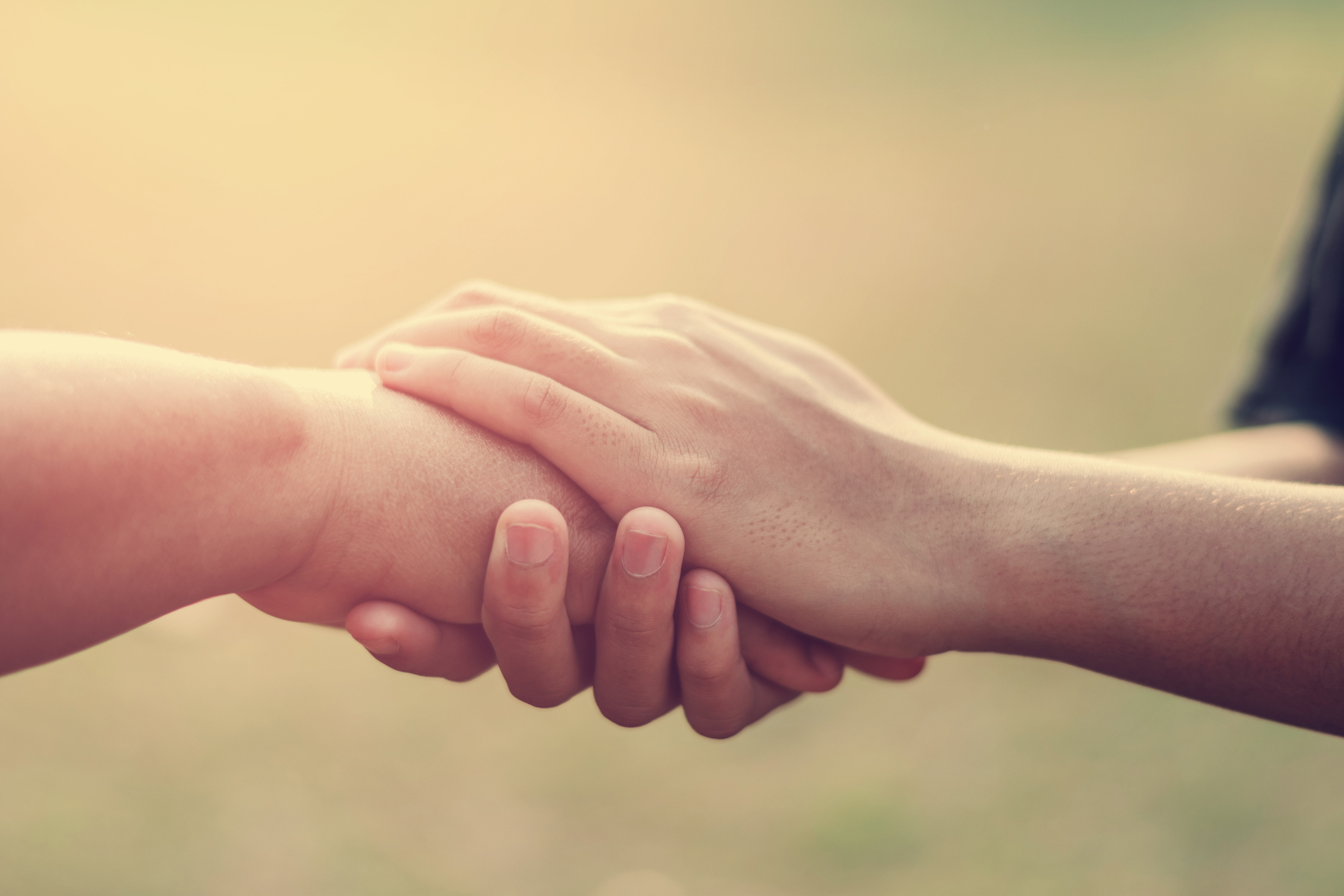 People old and young hand holding with sunset background