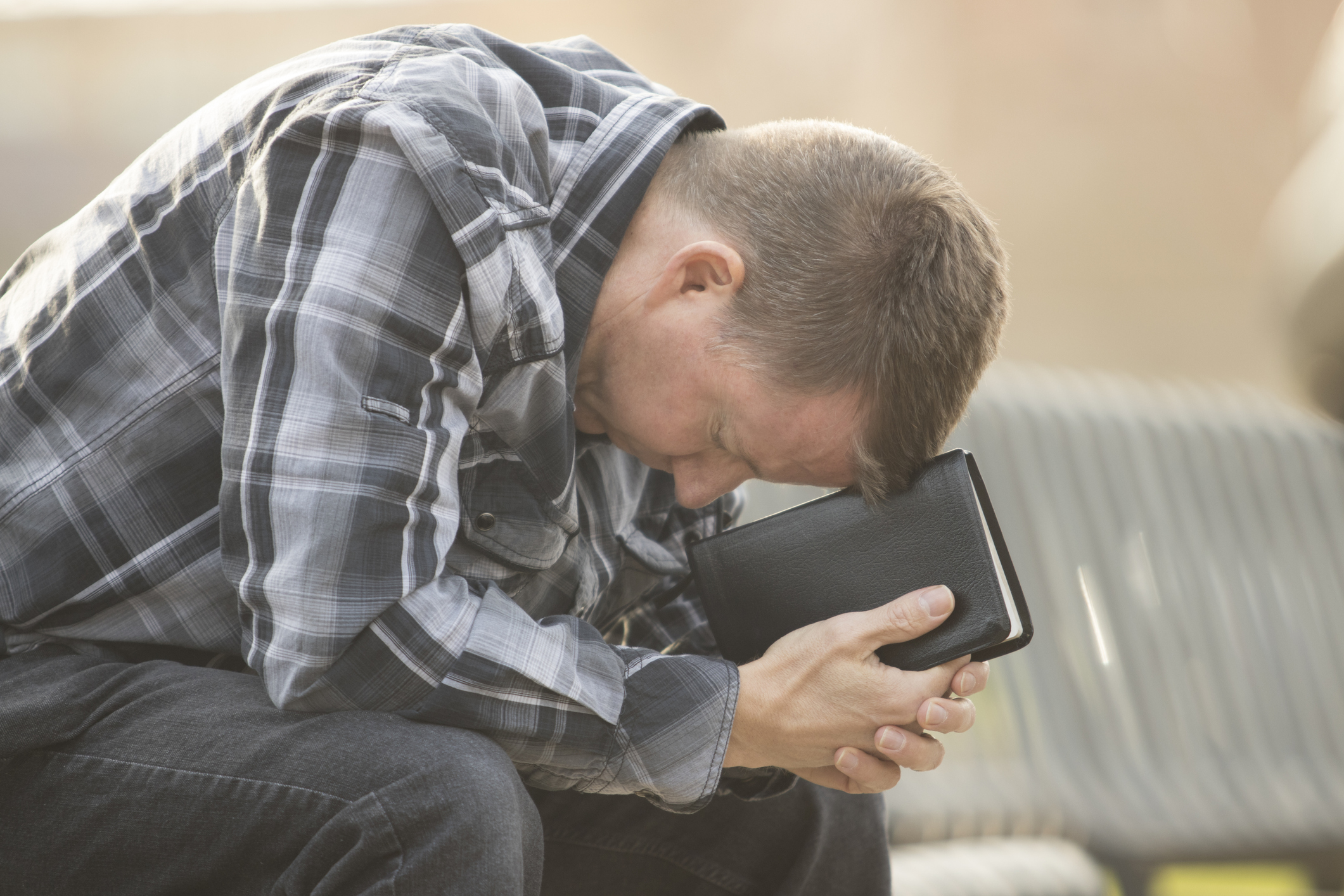 Man sitting on bench with Bible