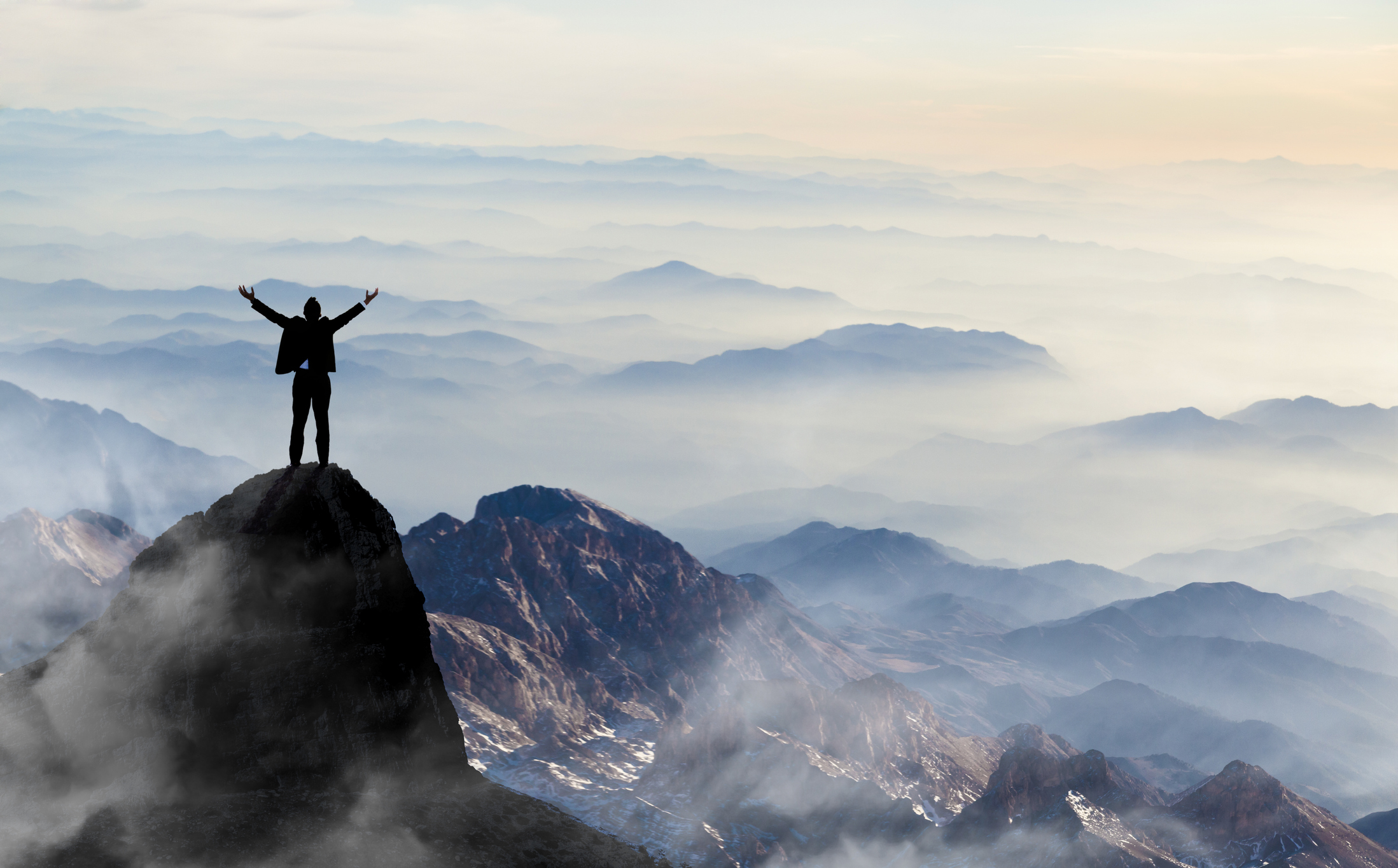 A man standing on the top of a mountain