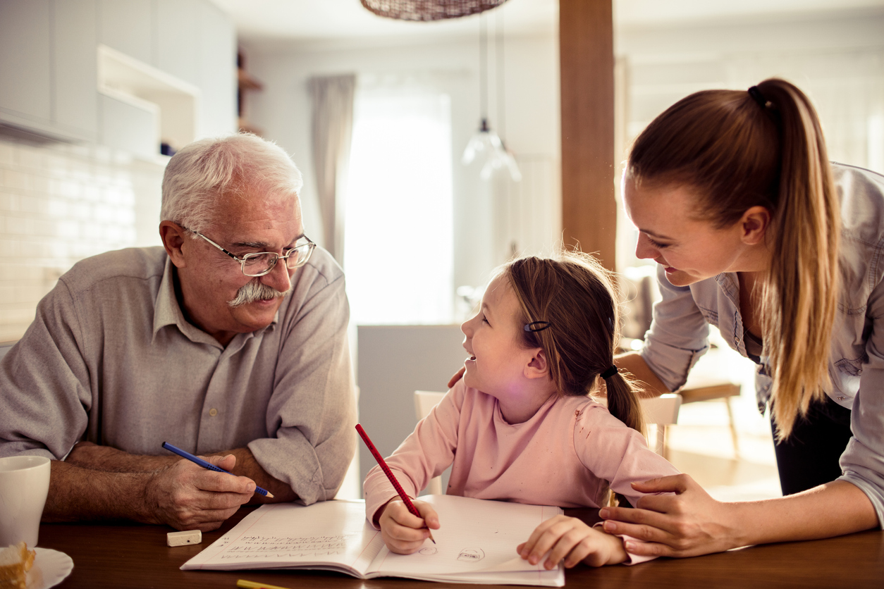 Close up of a grandfather helping out his granddaughter with schoolwork