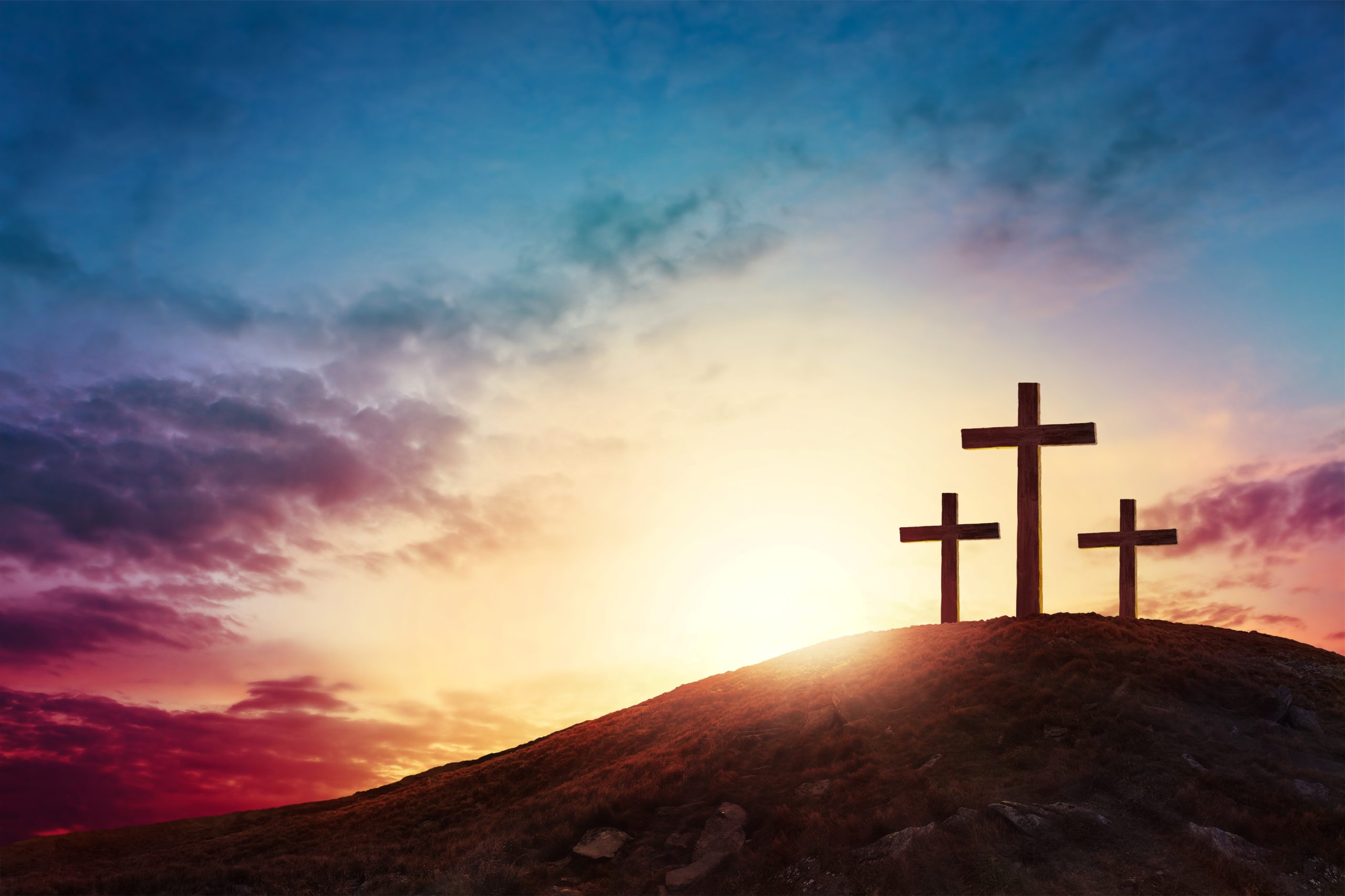 Silhouette cross on Calvary mountain sunset background