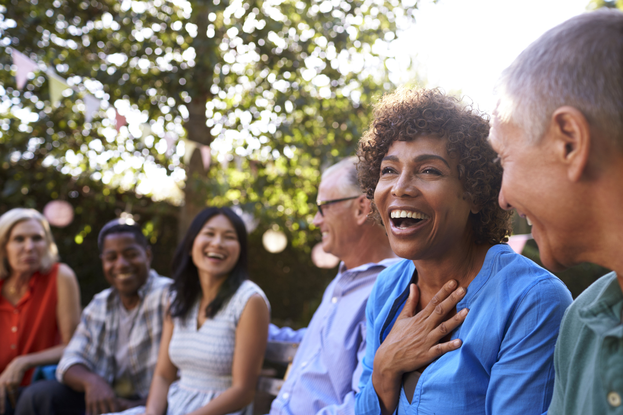 Group of mature friends socializing in backyard together