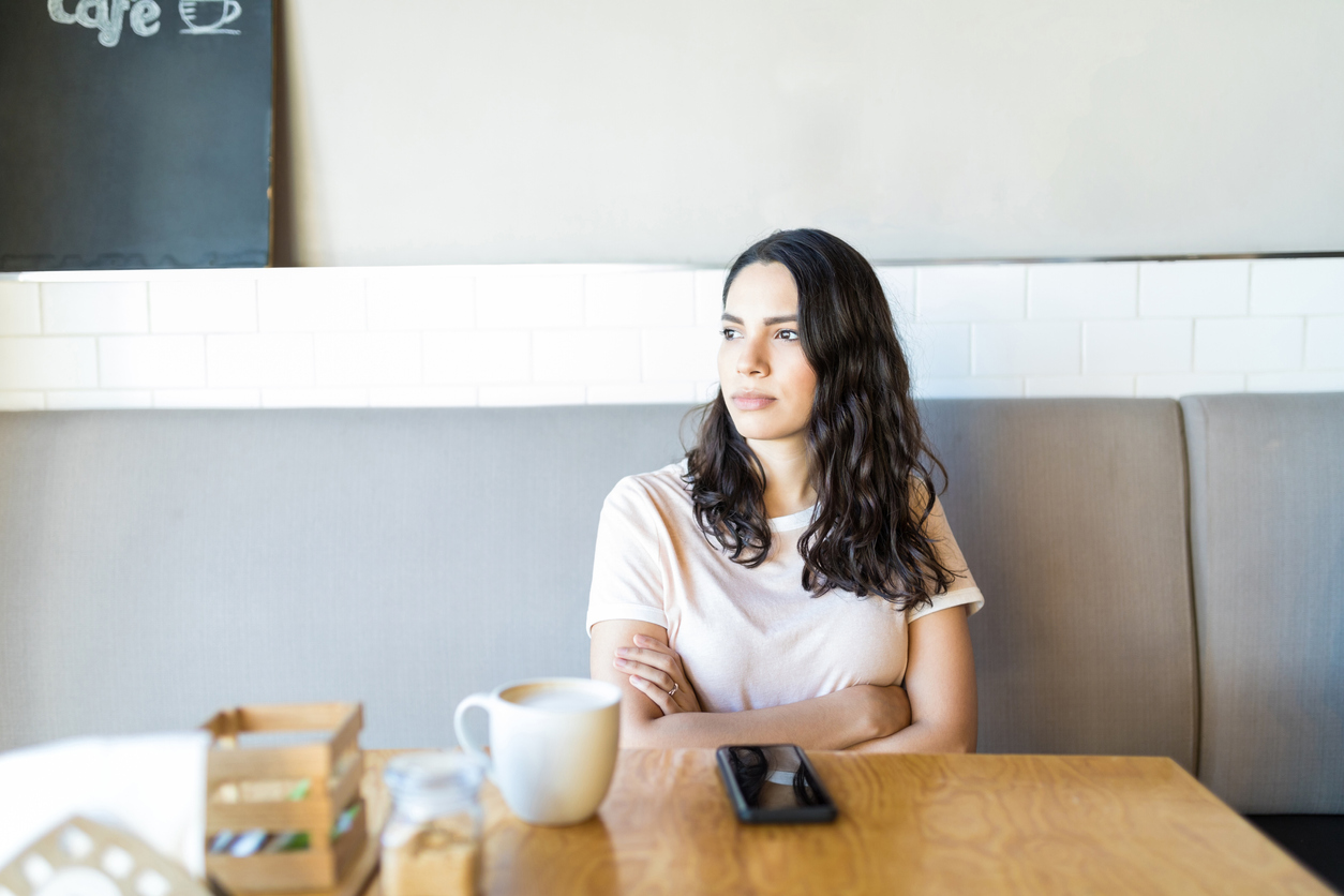 Woman Anticipating While Expecting Boyfriend In Coffee Shop