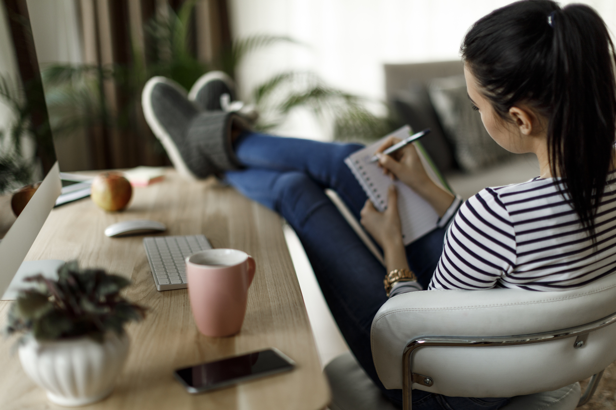 Young woman working at home writing in journal