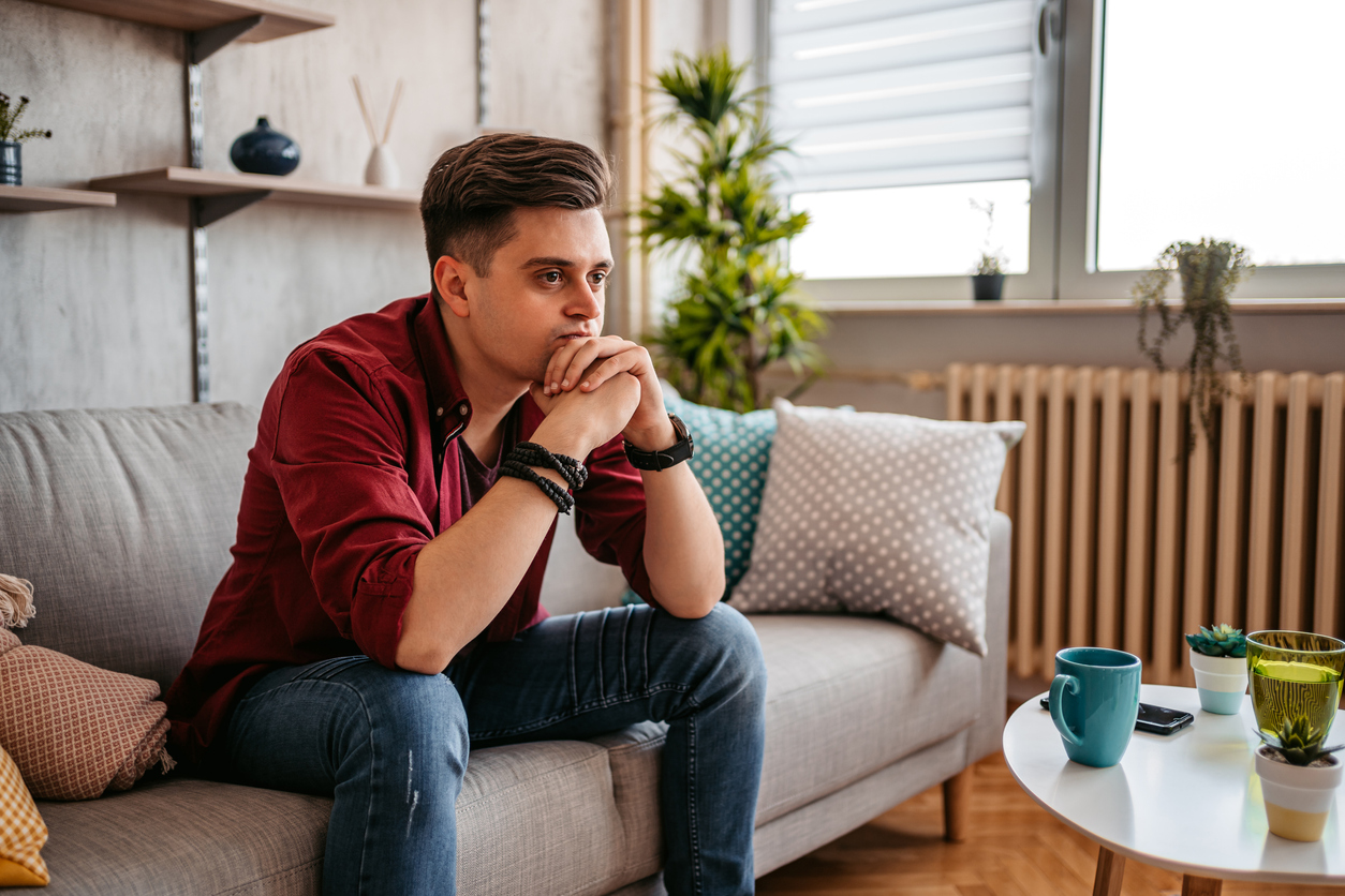 Man sitting alone at home looking sad and distraught