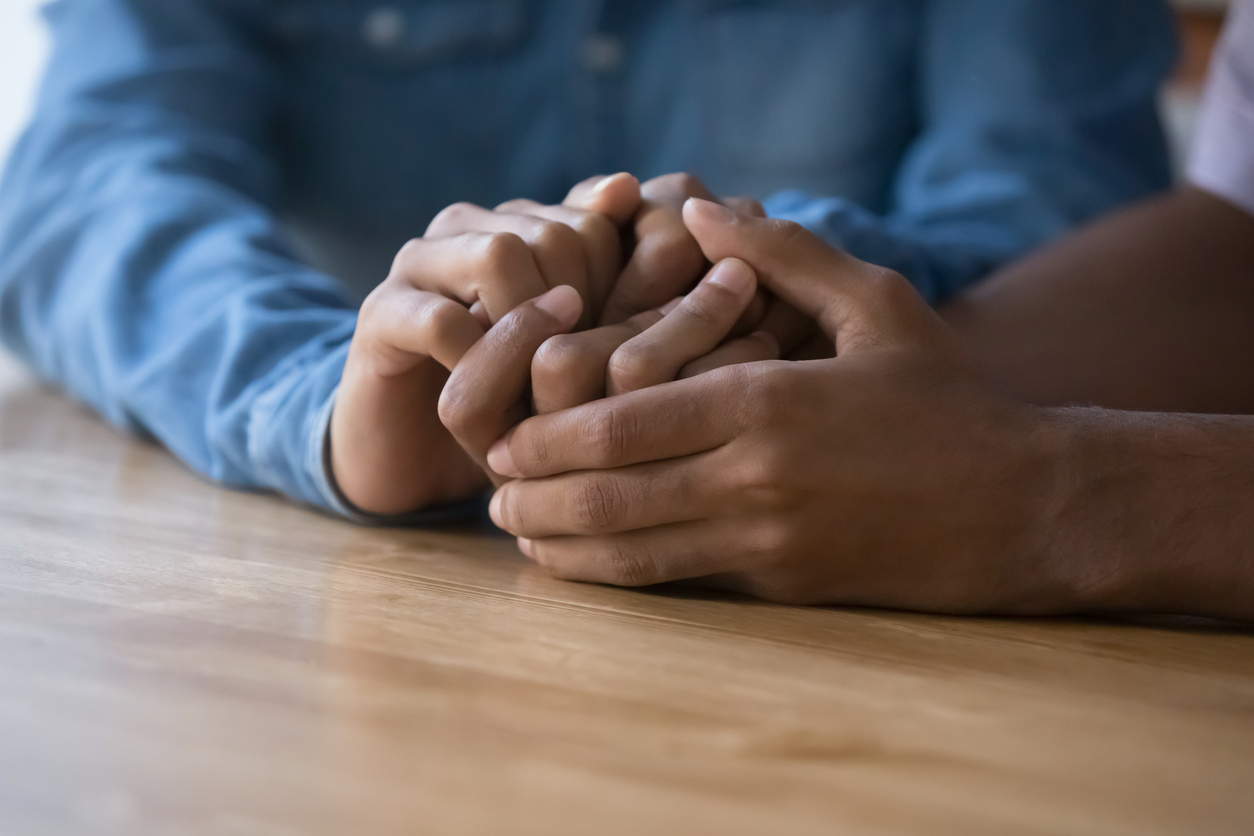 Closeup African couple holding hands during confidential conversation