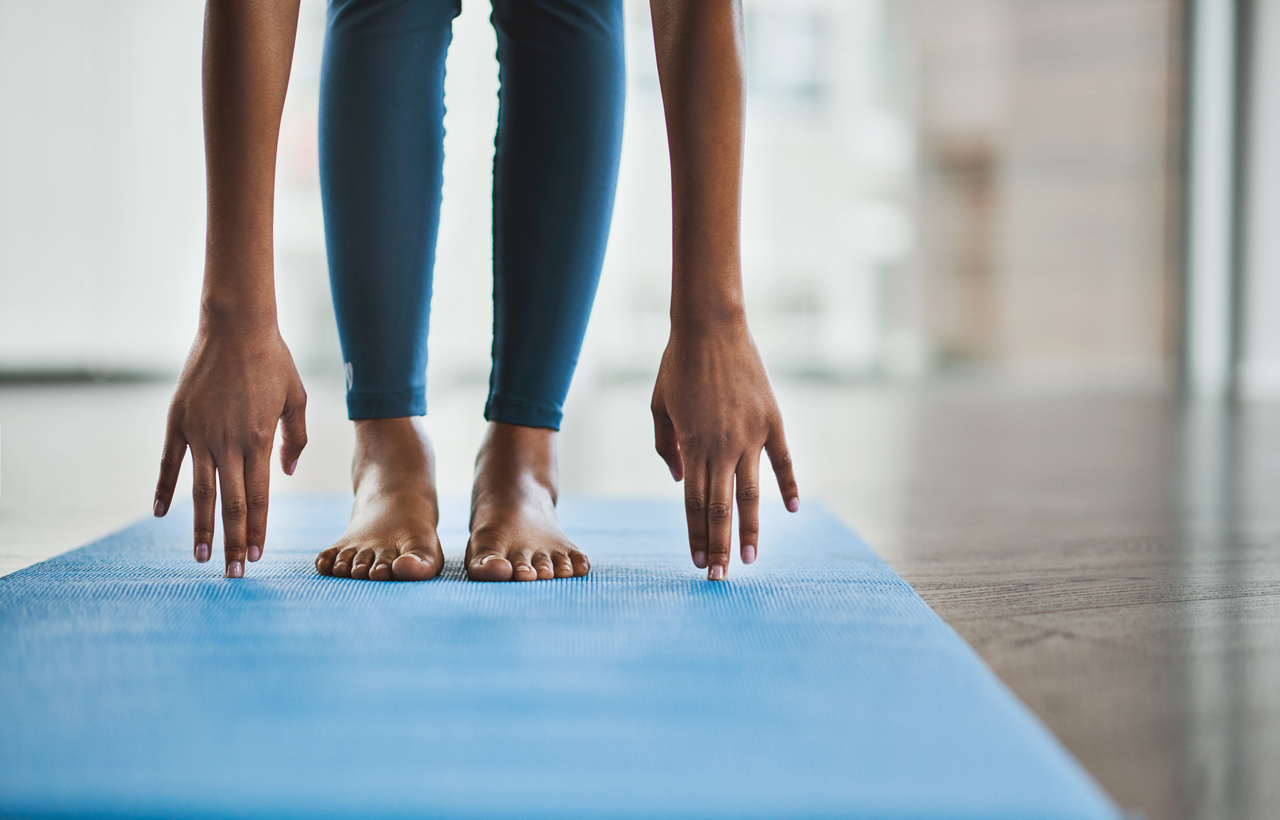 Shot of an woman practicing a de-stress stretching routine at home