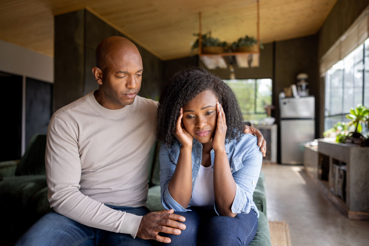 Loving husband consoling his sad wife at home
