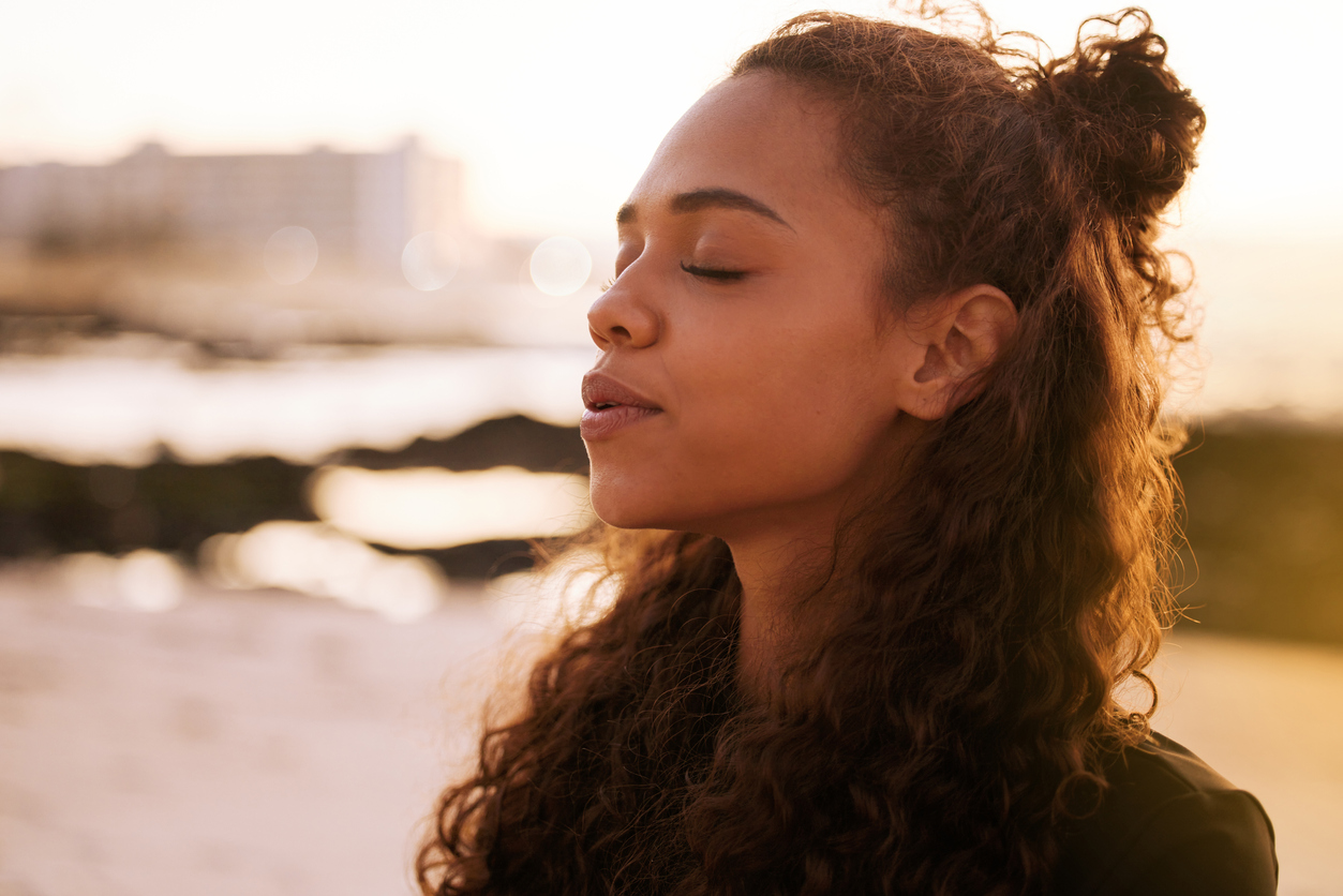 Young woman practicing meditation on a beach