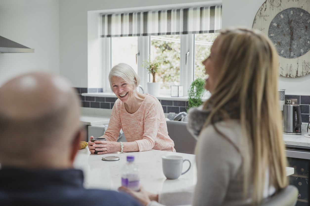 Happy senior mom is enjoying catch up time with her daughter and husband