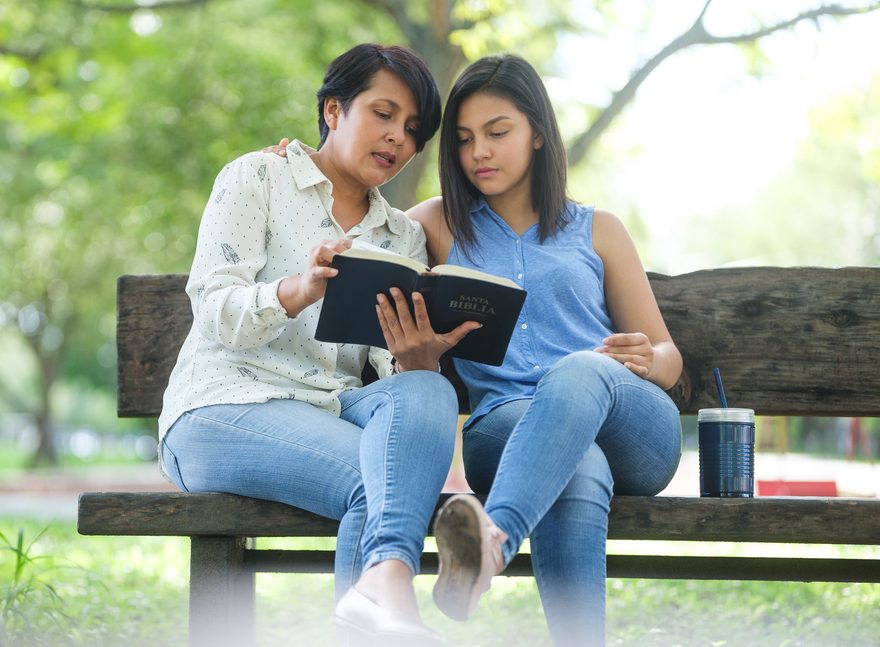 Mother and daughter meditating on the Bible together