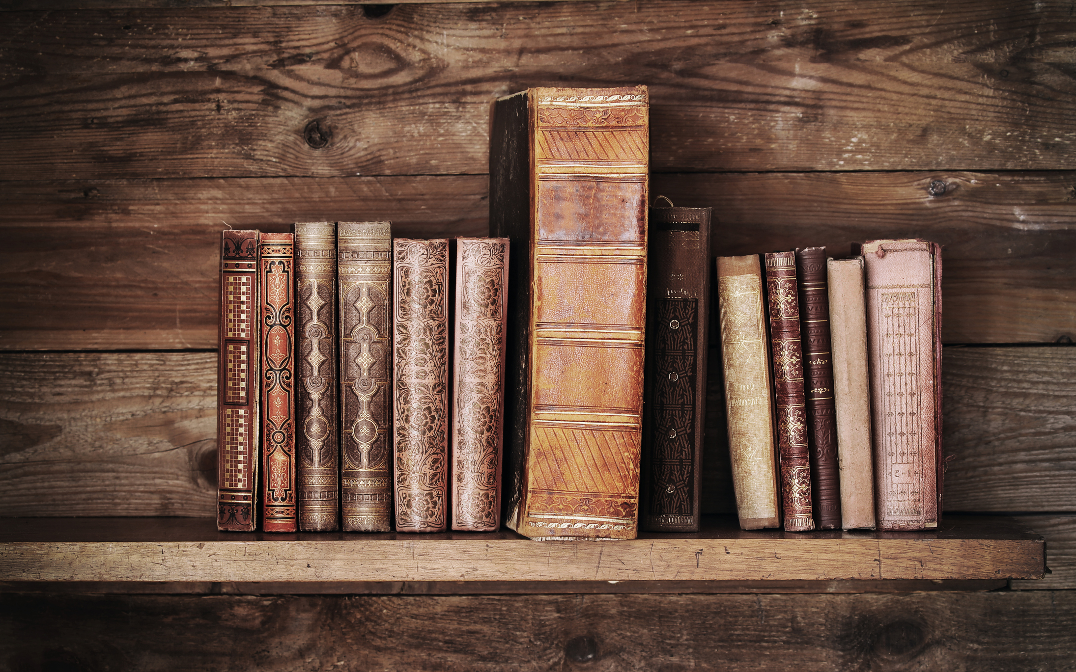 Old books on wooden shelf