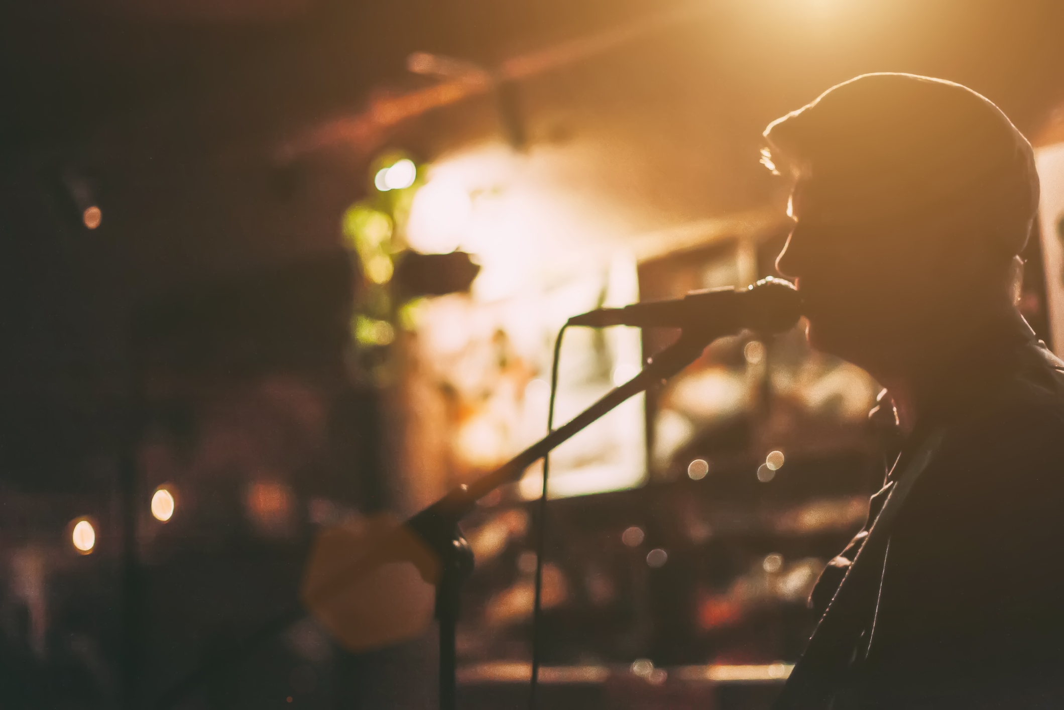 A male singer on a stage performing with guitar