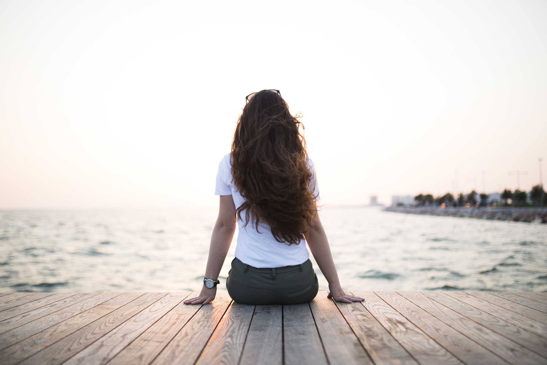 Young woman sitting looking sunset