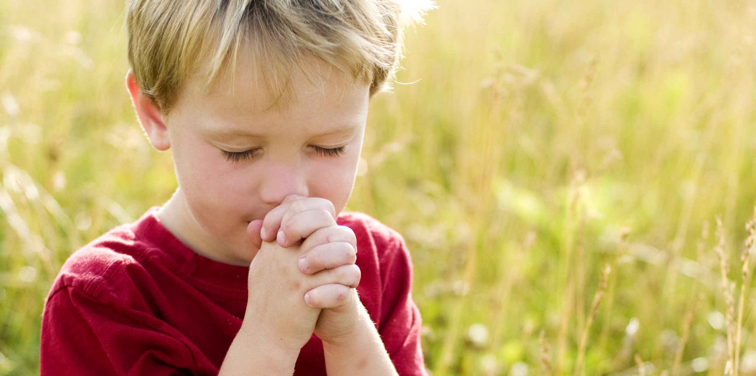 Child praying outdoors