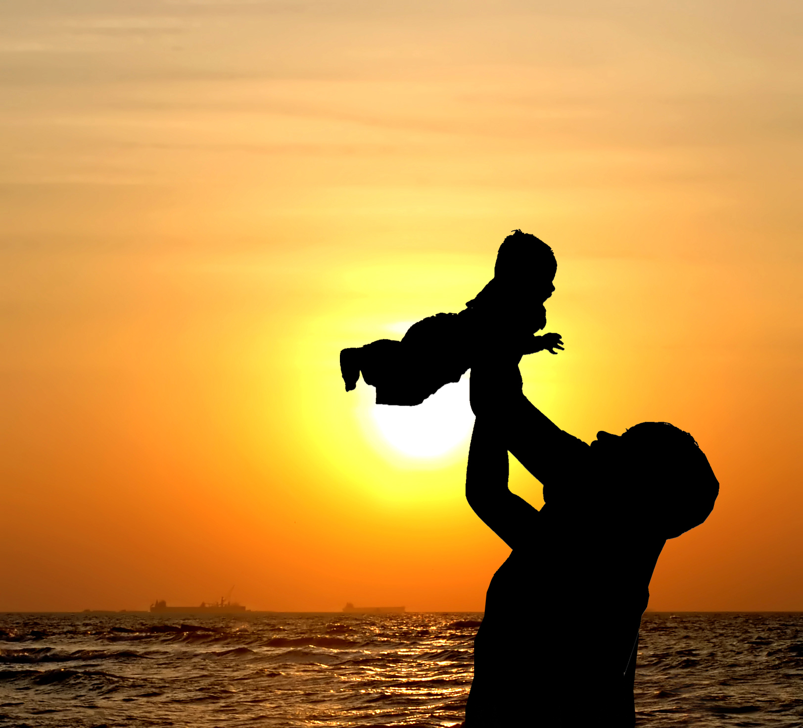 Woman with a child in her arms at sunset
