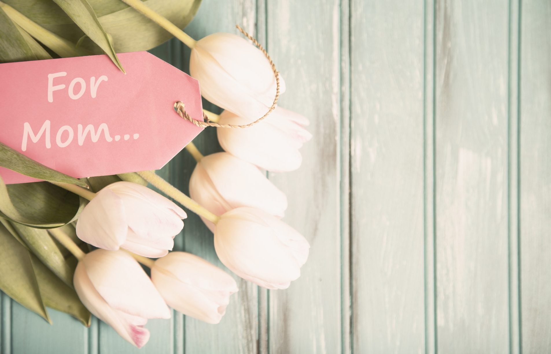 Happy Mother's Day pink tulip flower bouquet on teal wooden background