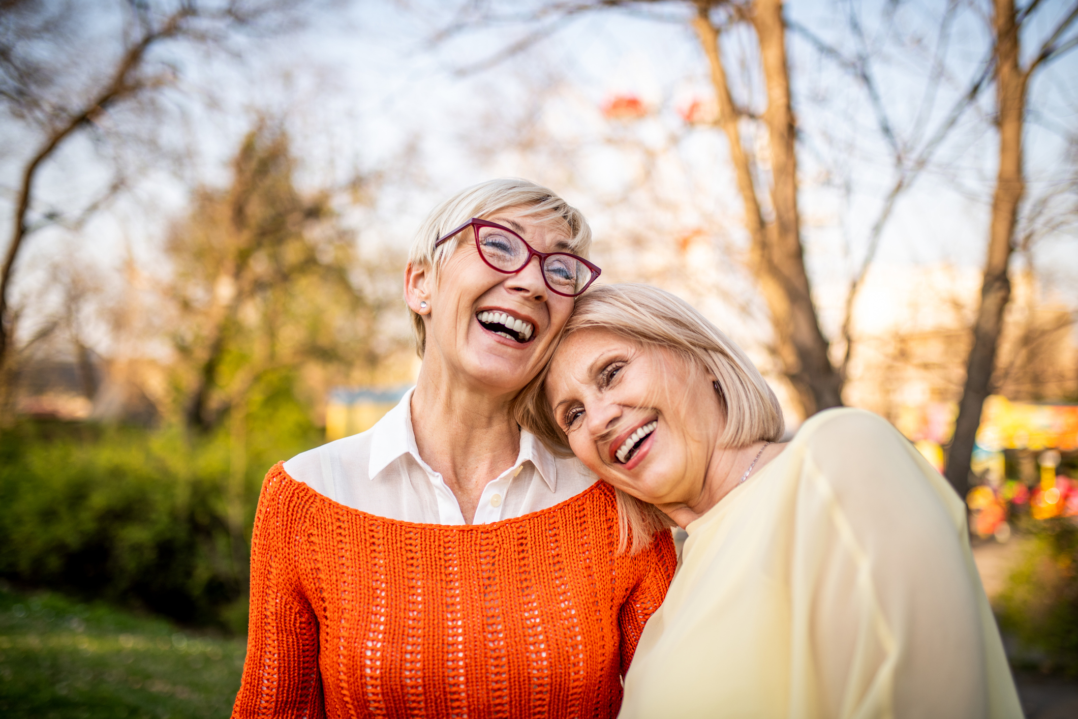 Two senior women laughing at the park