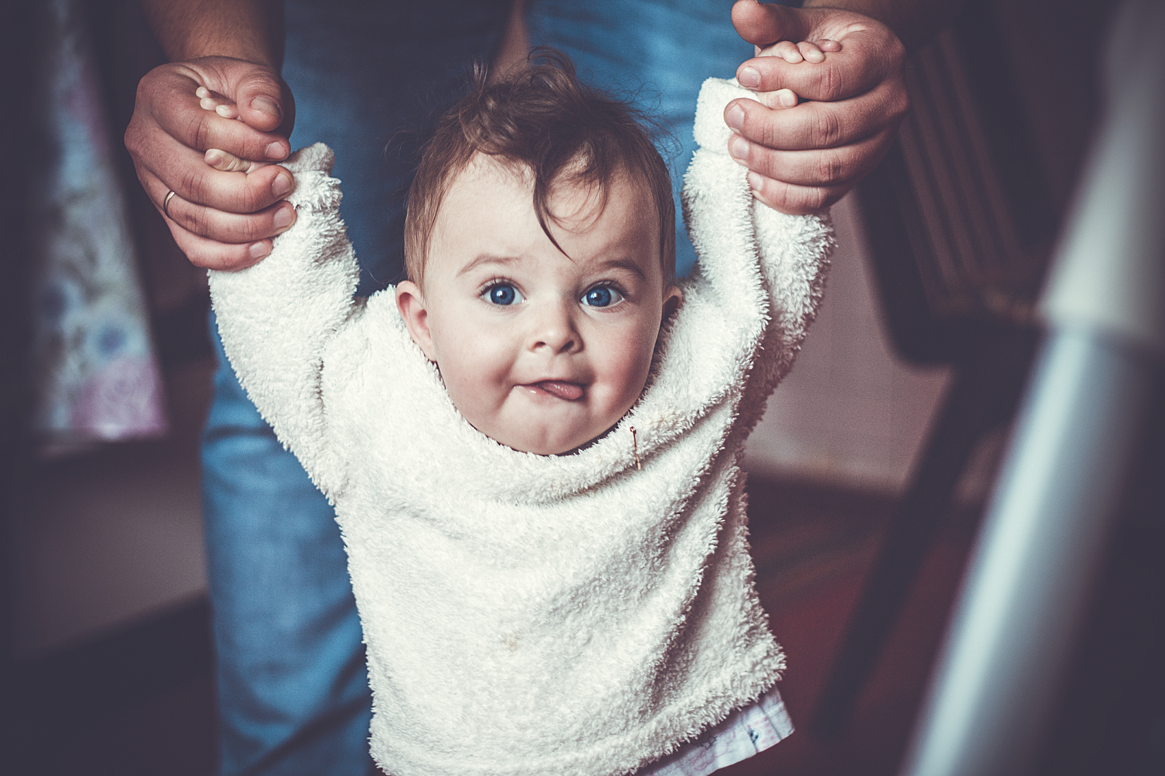 Child held by parents' hands