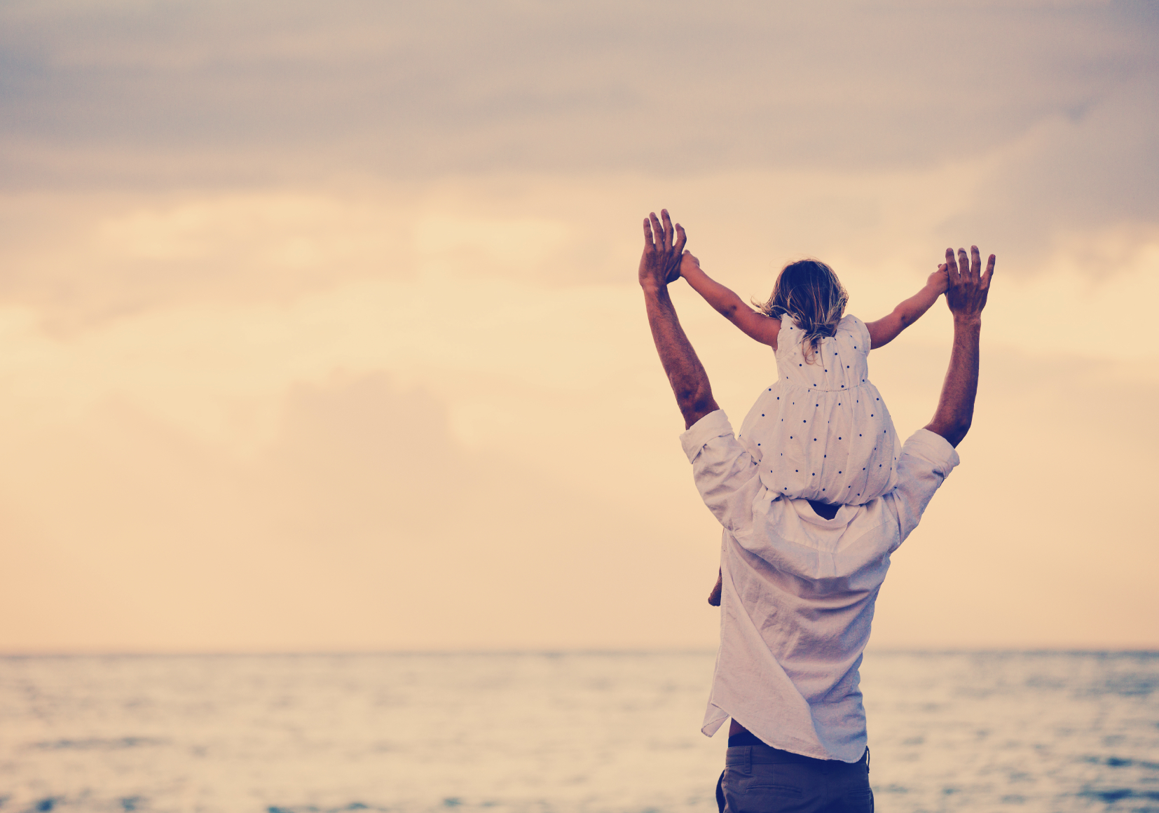 The father carries the child on shoulders