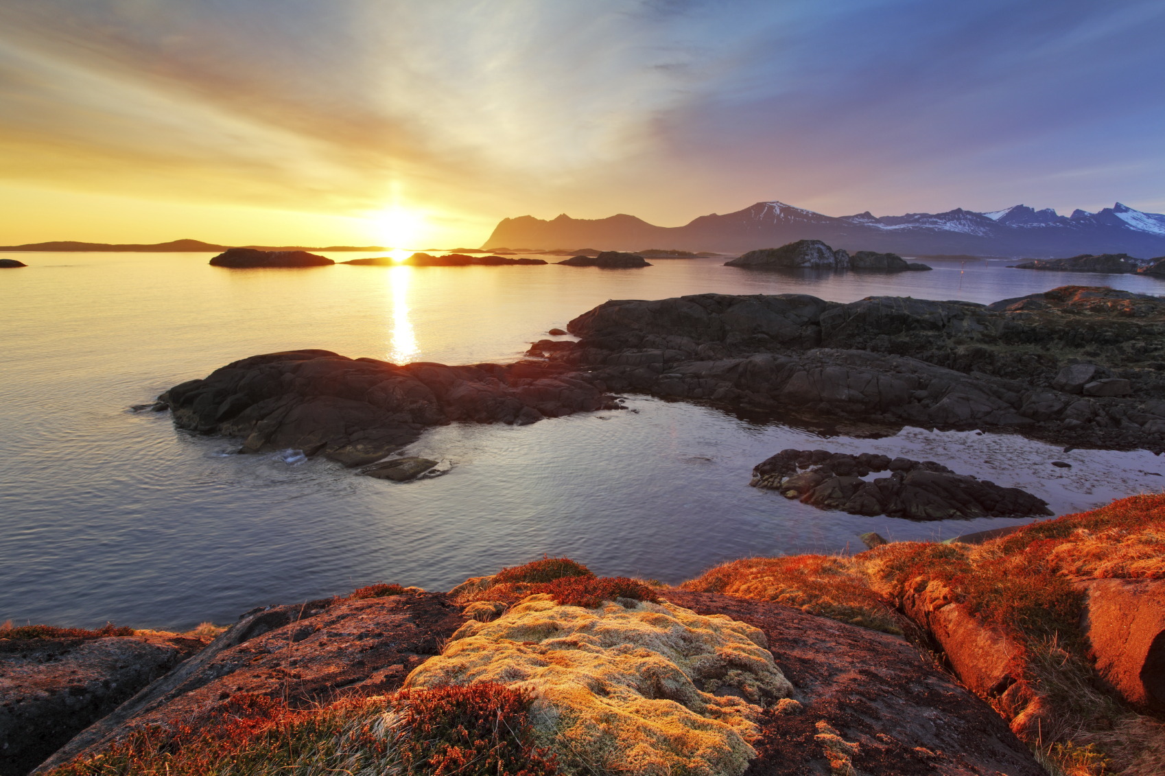 Lake and rocks against the background of the setting sun
