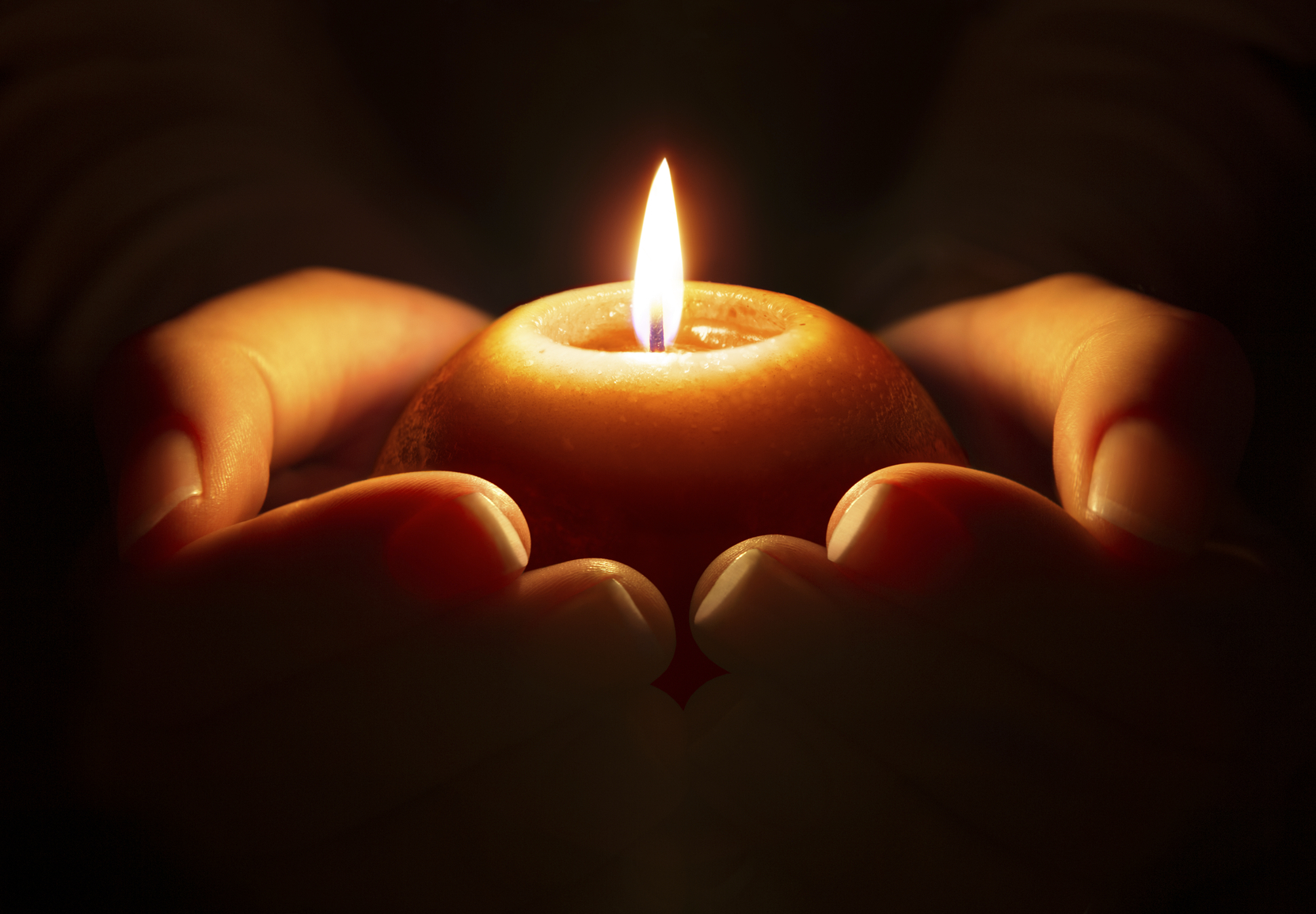 Hands holding a candle