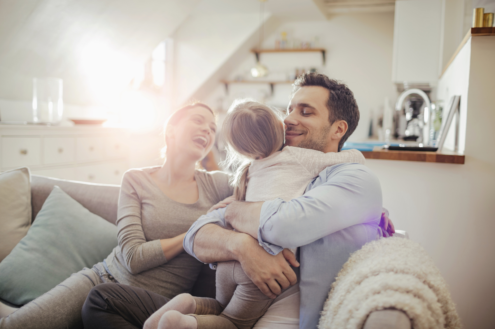 Happy family cuddling on the sofa at home