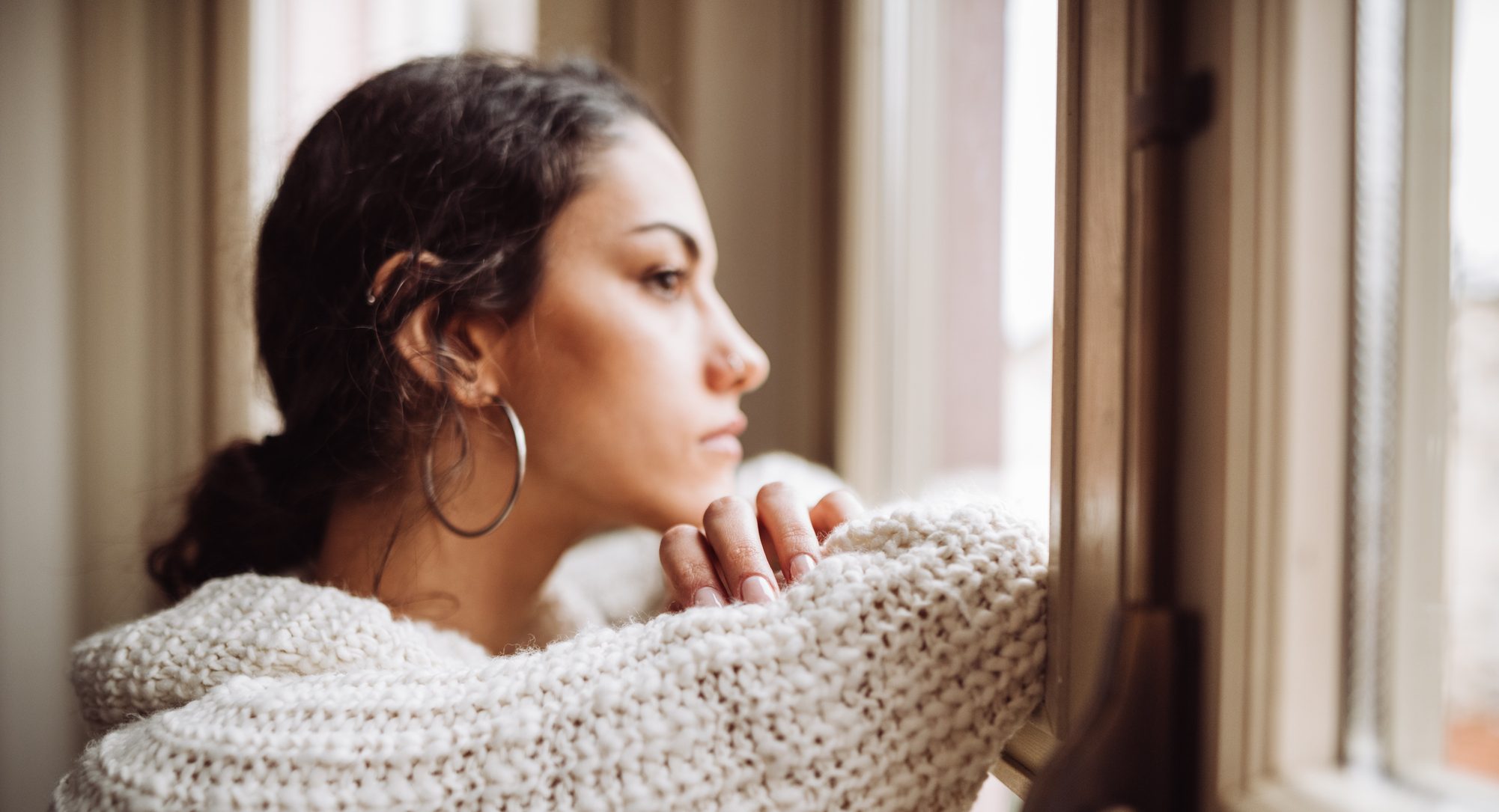 Pensive woman in front of the window