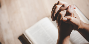 someone praying over their Bible