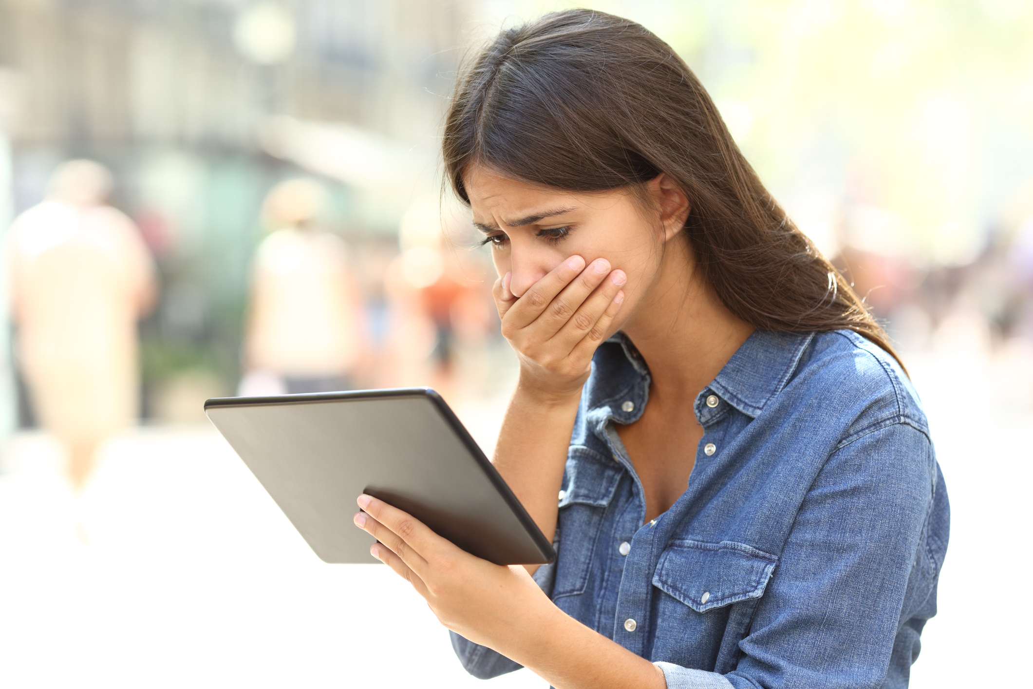 Woman emotionally responding to what she sees on a tablet