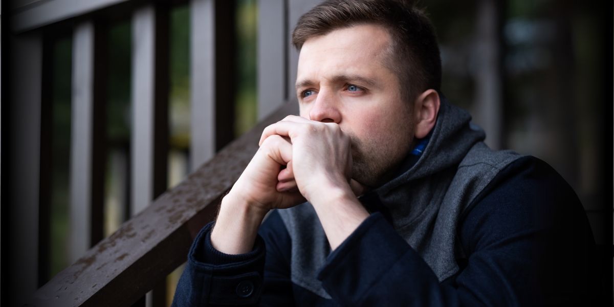 A man sitting on the porch and thinking intensly